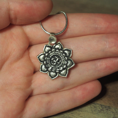 collier pour femme en argent mandala om quartz blanc sur une main