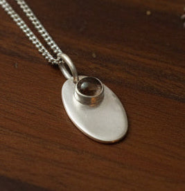 Sterling silver necklace with an 11 mm stone pendant and flower design