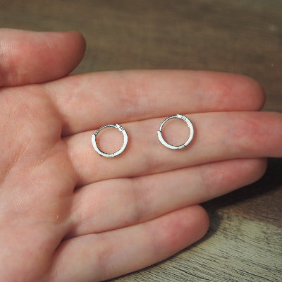 boucle d’oreille anneau pour femme avec texture lignée sur une main en argent sterling