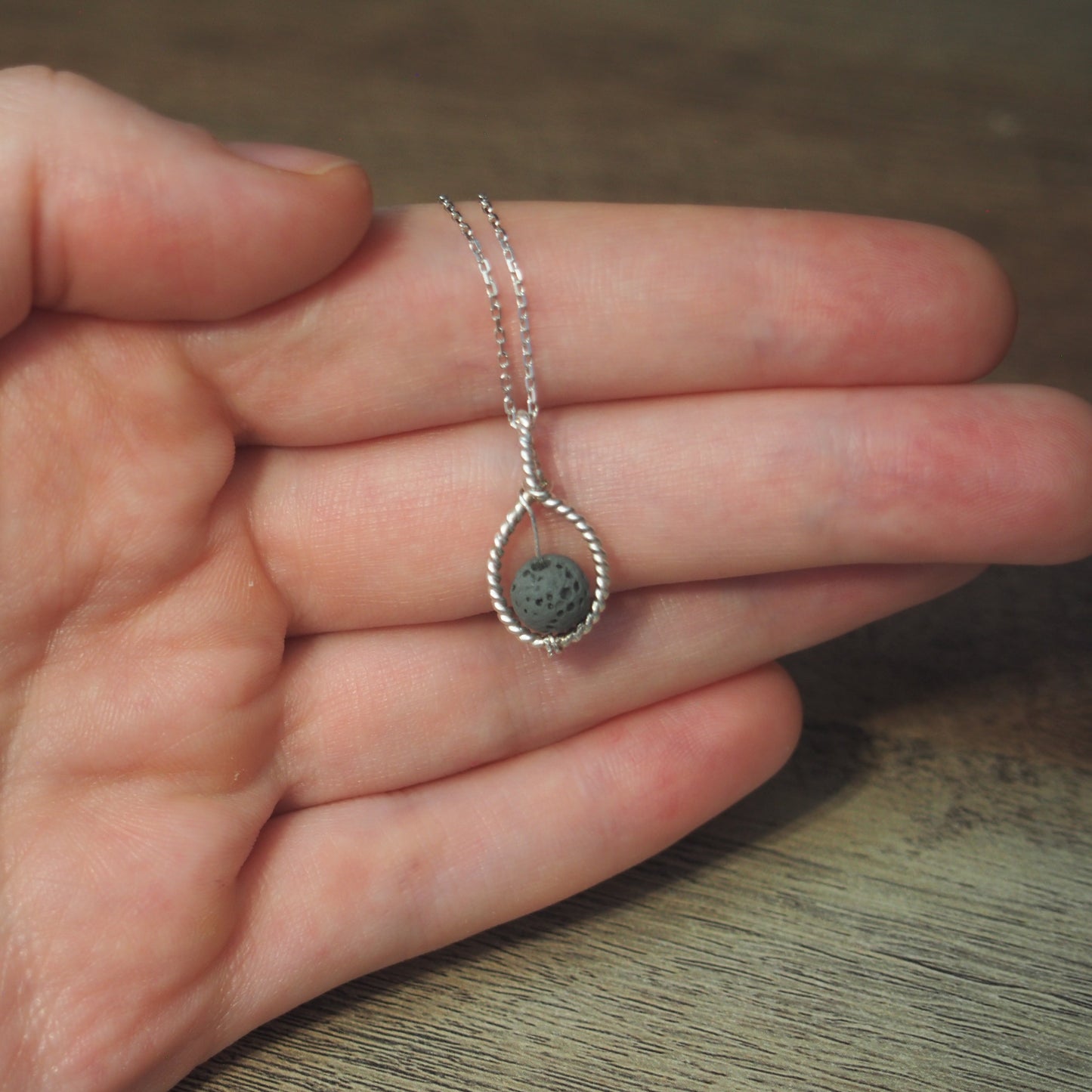 collier femme argent 925 pierre de lave gris sur une main