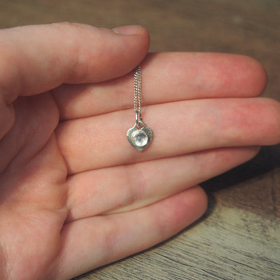 collier pour femme en argent cœur en quartz blanc naturel sur une main
