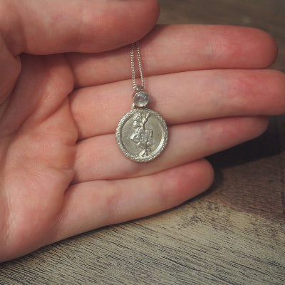 collier pour femme en argent fleur de cerisier en quartz blanc naturel sur une main