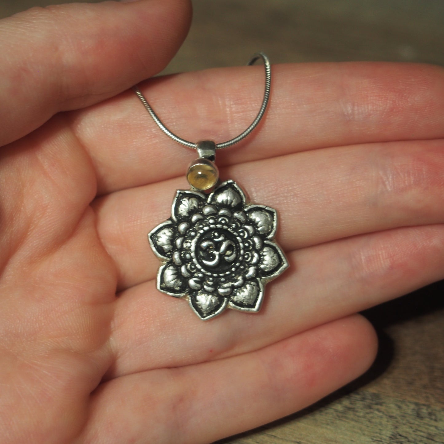 collier pour femme en argent mandala om Citrine sur une main
