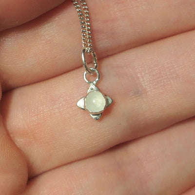 collier pour femme en argent petite fleur en quartz rose sur une main