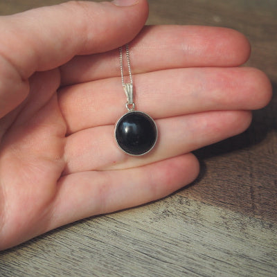 collier pour femme en argent pierre onyx noir 12 mm sur une main